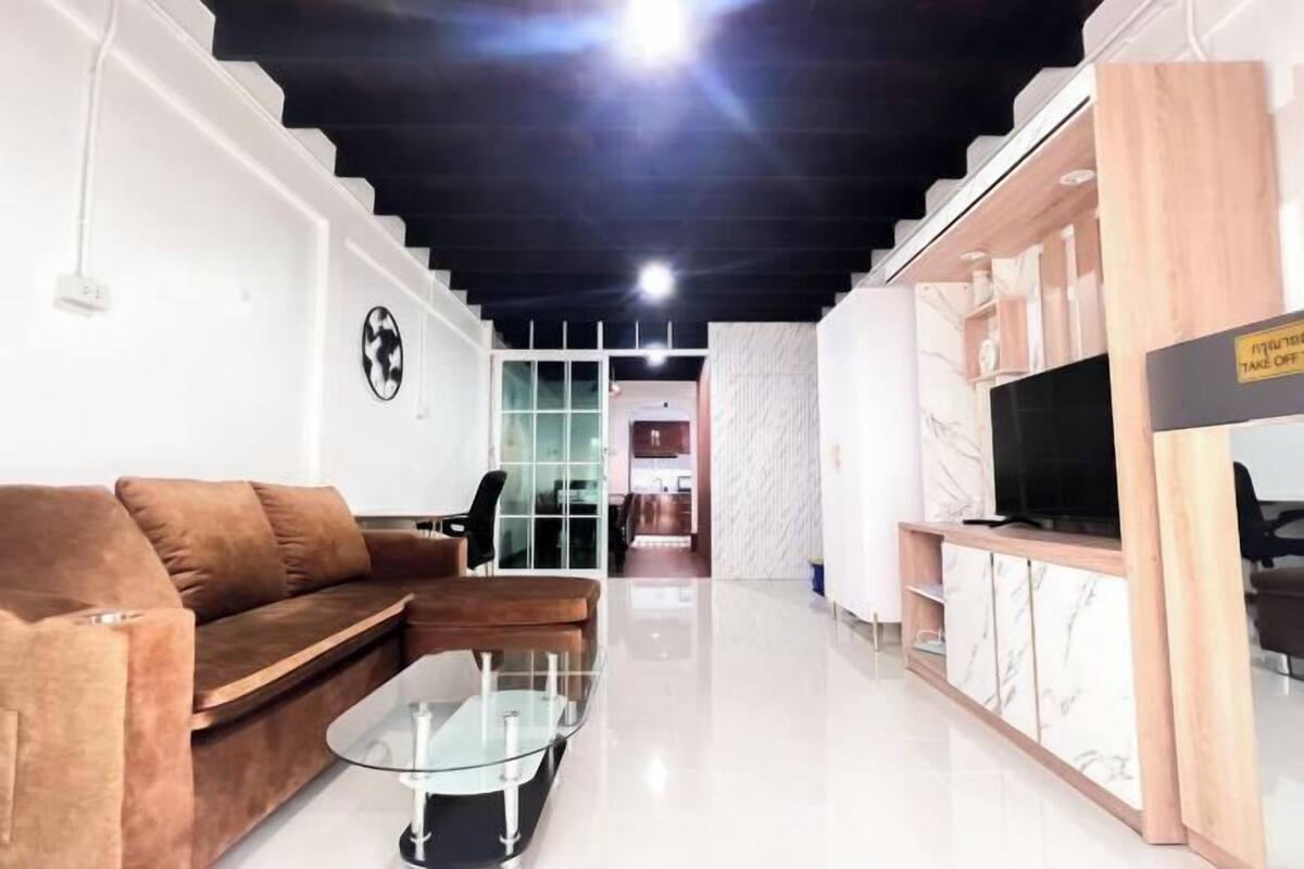 A modern living room with a sofa, coffee table, and TV stand.
