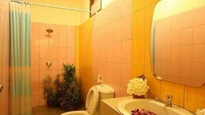 Een badkamer met toilet, bidet, wastafel en spiegel.