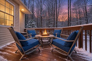 A deck with a fire feature, surrounded by chairs and a table. - Lake Getaway | FREE Golf Cart + Fire Pit + Games (Pocono Lake)