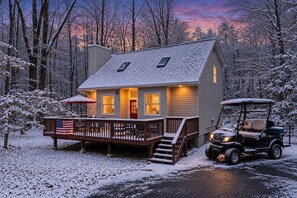 A two-story cabin with a deck, a covered porch, and a golf cart parked in front. - Lake Getaway | FREE Golf Cart + Fire Pit + Games (Pocono Lake)
