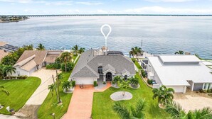 A coastal property with a central building, a driveway, and a view of the sea.