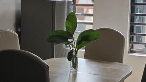 A dining table with a vase of green leaves. - Lagos Wanhao Hotel (Ikeja)