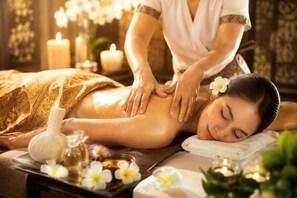 Eine Massage in einem Raum mit Kerzen und Blumen.