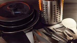 A kitchen counter with a coffee maker, a metal strainer, a pair of scissors, and a white napkin.
