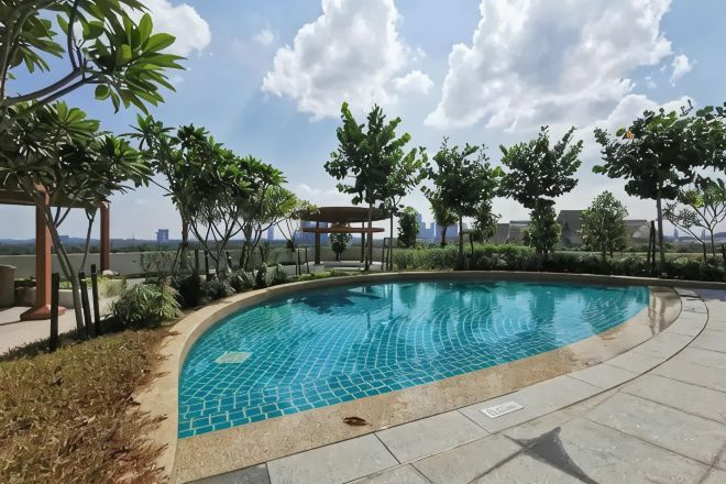 A swimming pool with a tiled edge, surrounded by greenery and a pergola structure.
