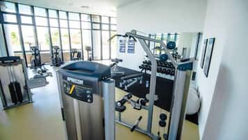 Une salle de sport équipée de matériel d’exercice, dotée de grandes fenêtres et d’un intérieur propre.