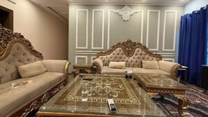 A luxurious room with two ornate sofas, a glass coffee table, and a patterned rug. - AoLai Hotel (Islamabad)