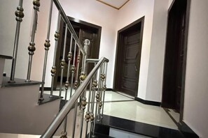 Una escalera con barandilla de metal y piso blanco y negro.