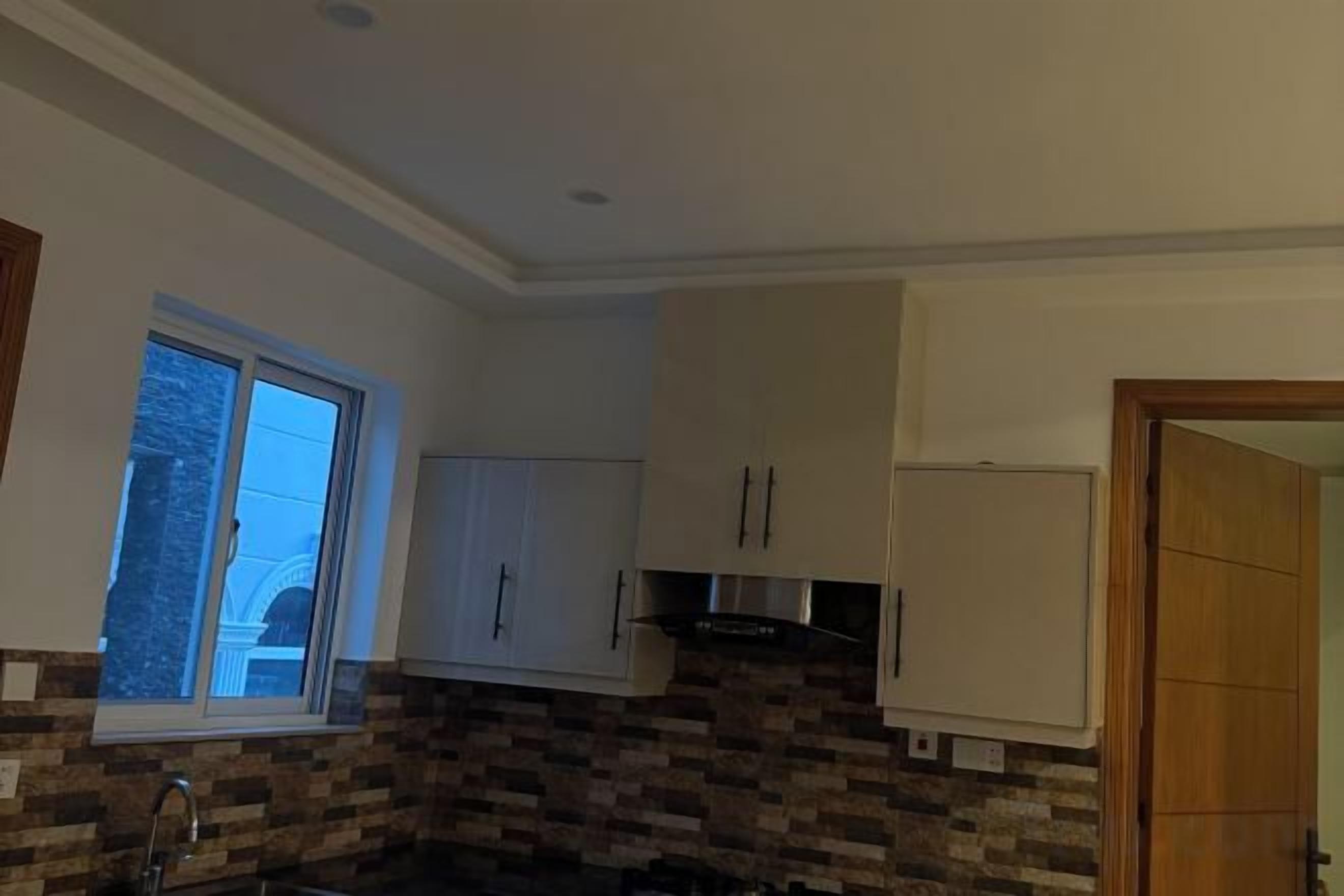 Una cocina con ventana, armarios y encimera.
