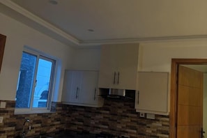 Una cocina con ventana, armarios y encimera.