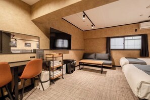 Een moderne hotelkamer met een flatscreen televisie, een bank, een bed, een bureau met stoelen en een kleine tafel.