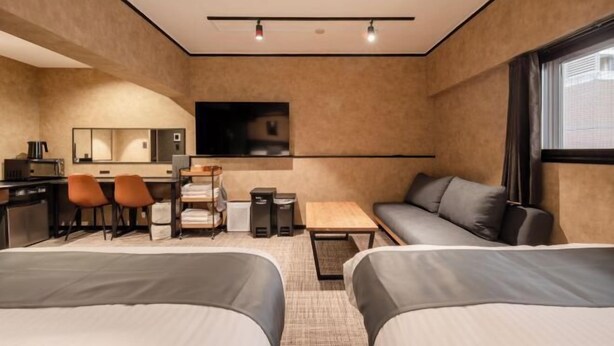 A hotel room with two beds, a desk with chairs, a TV, and a sofa. - Hotel Akasaka Heights (Fukuoka)
