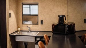 A modern kitchen with a sink, a coffee machine, and a mirror on the wall. - Hotel Akasaka Heights (Fukuoka)