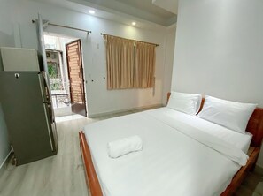A hotel room with a bed, a wardrobe, a door leading to a balcony, and a window with curtains. - Violet Star Hotel & Spa - Hostel (Ho Chi Minh City)