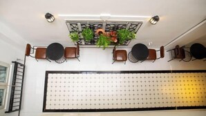 A dining area with a long table, chairs, hanging plants, and a decorative ceiling light fixture. - Violet Star Hotel (Ho Chi Minh City)