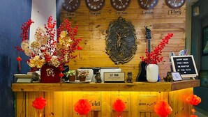 Un comptoir d’accueil avec des horloges indiquant l’heure à Tokyo, New York, au Vietnam, à Londres et à Paris.