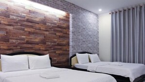 A hotel room with two beds, a brick-patterned wall, and a large window with curtains. - Violet Star Hotel (Ho Chi Minh City)