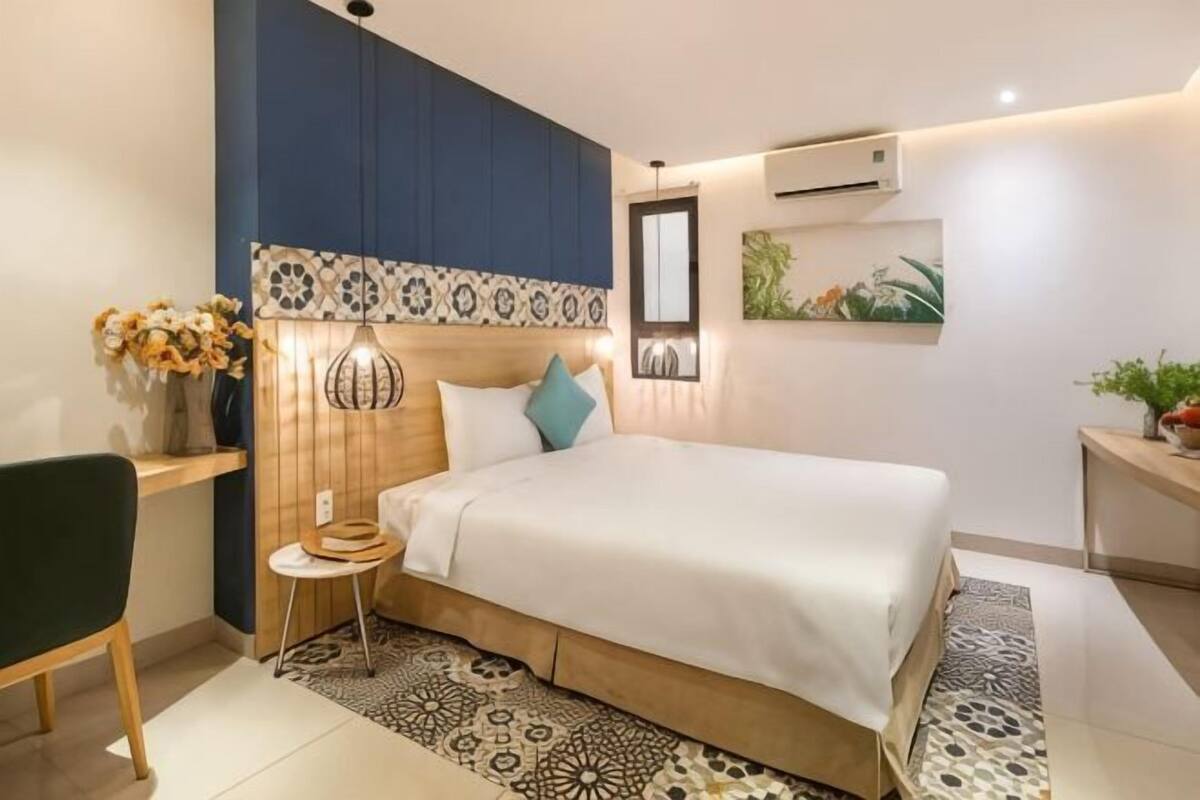 A modern bedroom with a bed, bedside table, chair, and decorative elements.