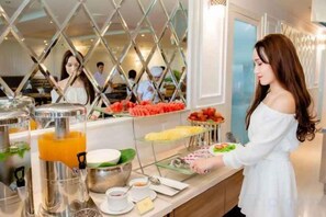 A buffet setup with various food items and a beverage dispenser.