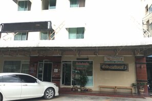 Un edificio con un letrero que indica un restaurante y un coche estacionado adelante.