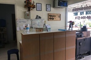 Un mostrador de recepción con encimera de madera, una pizarra y diversos objetos expuestos.