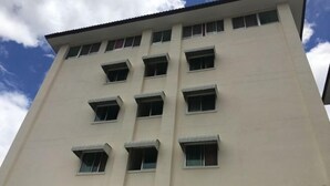 Een meerlaags gebouw met een vlakke gevel en rechthoekige ramen.