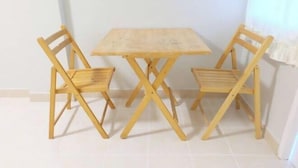 Een kleine houten tafel met twee stoelen.