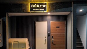 A hotel entrance with a sign reading "WASEDA STAR", a wooden door with a number "101", and a yellow bench outside. - Waseda Star 101. New interior! For your stay in Tokyo, stay at the Waseda Star, 2 minutes from Waseda Station in Shinjuku-ku! (新宿区早稲田町)