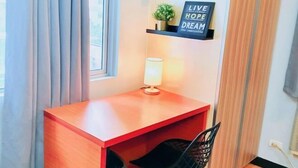 A small, neatly arranged room with a wooden desk, a chair, a lamp, and a motivational sign on the wall. - Maison at the Hill at Morgan Suites Mckinley Hill BGC Taguig (Taguig)