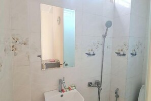 A bathroom with a sink, mirror, shower, and tiled walls. - The Owl Town 2 - Cosy Homestay Nearly Bui Vien Ewlaking Street (Ho Chi Minh City)