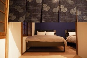 A bedroom with a bed, two bedside tables, and a window with curtains. - PIER & JETTY - Shiratori 2 (Osaka)