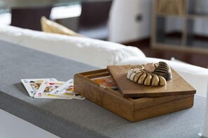 A wooden box with a chocolate dessert on a table in a room with a white sofa and a bookshelf in the background.