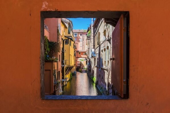 A narrow alleyway with buildings on either side, viewed through a window.