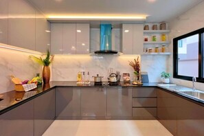 Una cocina moderna con una isla central, armarios empotrados y un ventanal que proporciona luz natural.