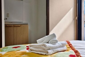 A hotel room with a bed, a door, and a wooden wardrobe. - Rest Collection Fushimi-Inari Kyoto (Kyoto)