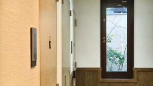 A hallway with a wooden door, a small window, and a doorbell. - Rest Collection Fushimi-Inari Kyoto (Kyoto)