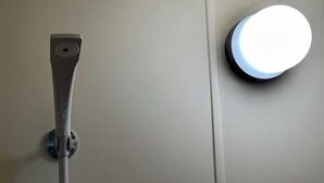 A wall-mounted light fixture and a vertical pole, likely part of a bathroom's infrastructure. - Rest Collection Fushimi-Inari Kyoto (Kyoto)