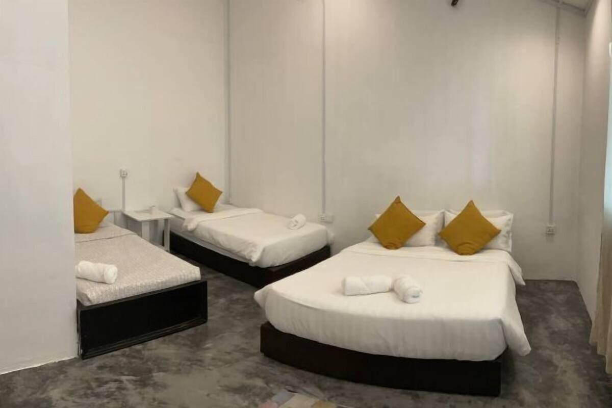 Une chambre d’hôtel avec deux lits simples, chacun étant équipé d’un oreiller et d’une table de chevet.