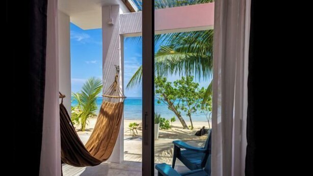 A room with a view of a beach, a hammock, and a chair. - Coral Reef Holidays (Tioman)