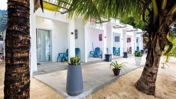 A covered outdoor area with seating and potted plants, likely a lounge or waiting area.