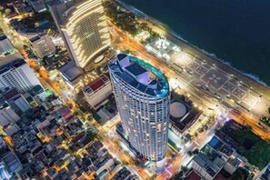 A high-rise hotel with a rooftop terrace, surrounded by other buildings and a waterfront. - Panorama Horizon Inn Nha Trang (Nha Trang)