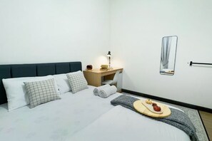 A neatly made bed with pillows, a bedside table with a lamp, a small mirror, and a tray with food. - Vista Bangi/ Jalan Reko / UKM / Kajang (Bangi)