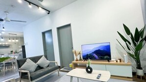 Ein modernes Wohnzimmer mit einer Couch, einem Couchtisch und einem Flachbildfernseher.