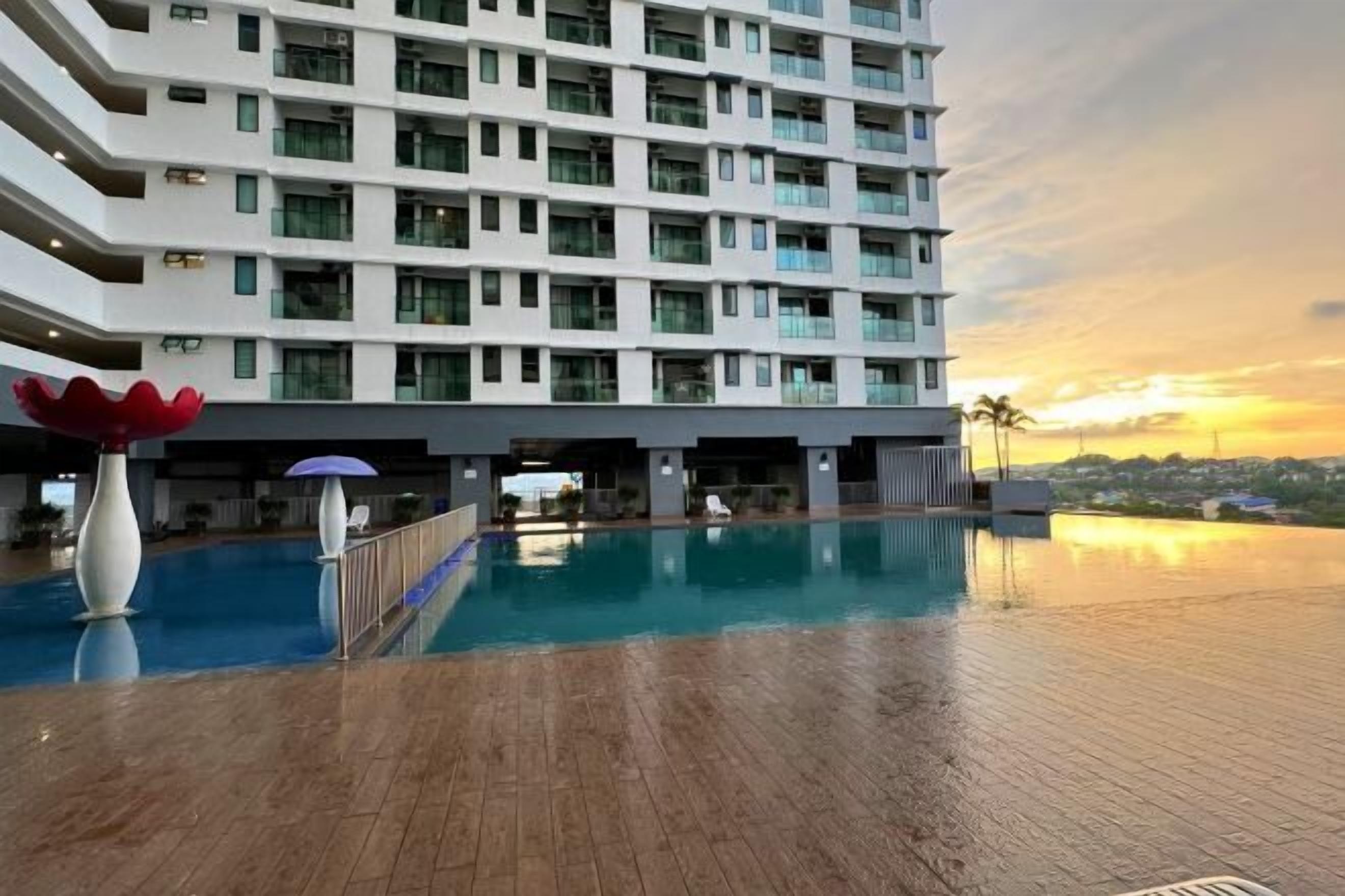 A modern hotel with a rooftop pool and a view of the sunset.