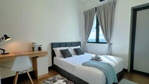 Ein modernes Schlafzimmer mit Bett, Schreibtisch, Stuhl und einem Fenster mit Vorhängen.