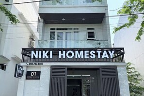 A building with a sign for 'NIKI HOMESTAY' and a contact number. - Niki Homestay (Hue)