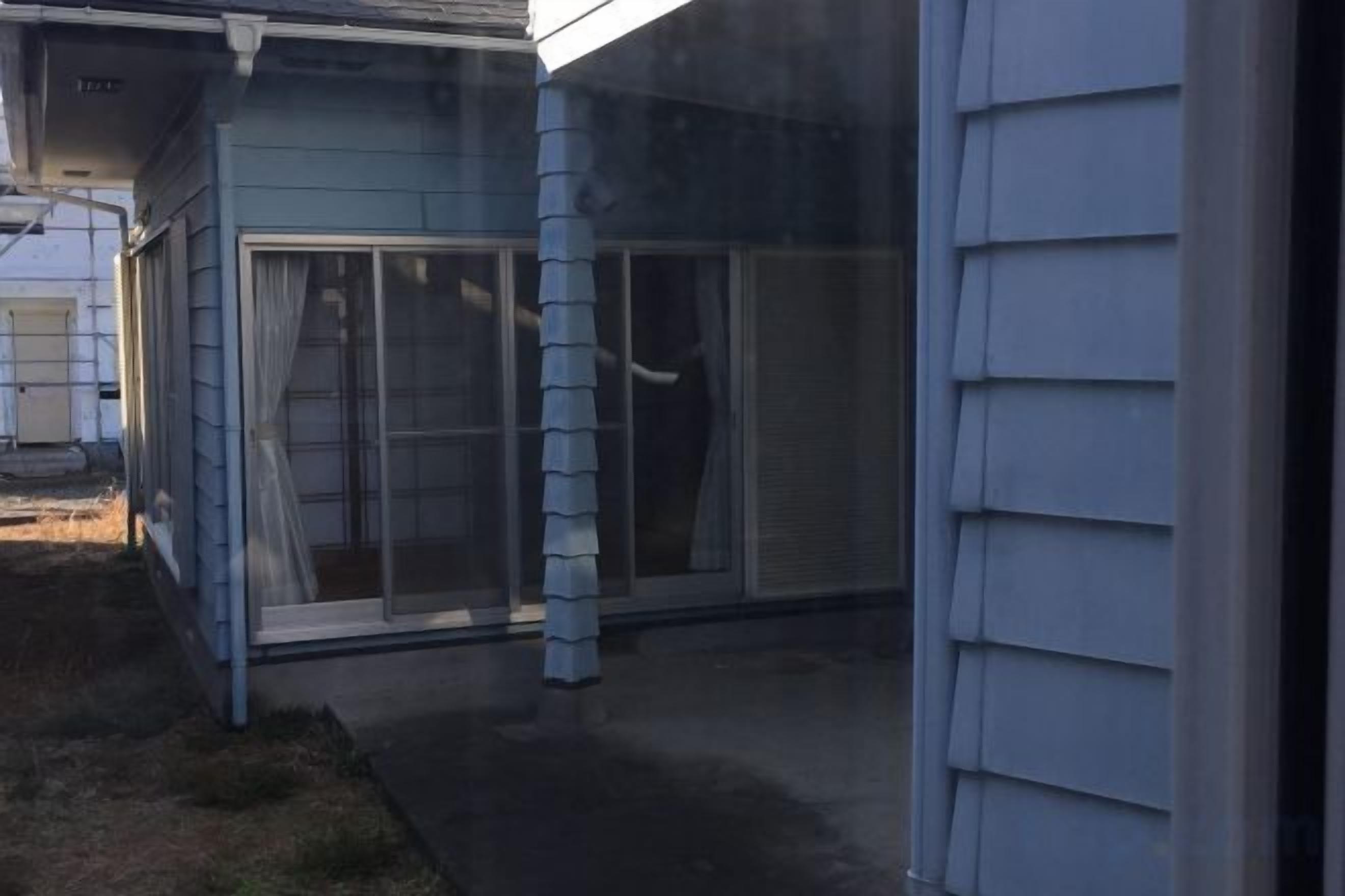 Uma casa com porta de garagem, porta de correr e uma janela.