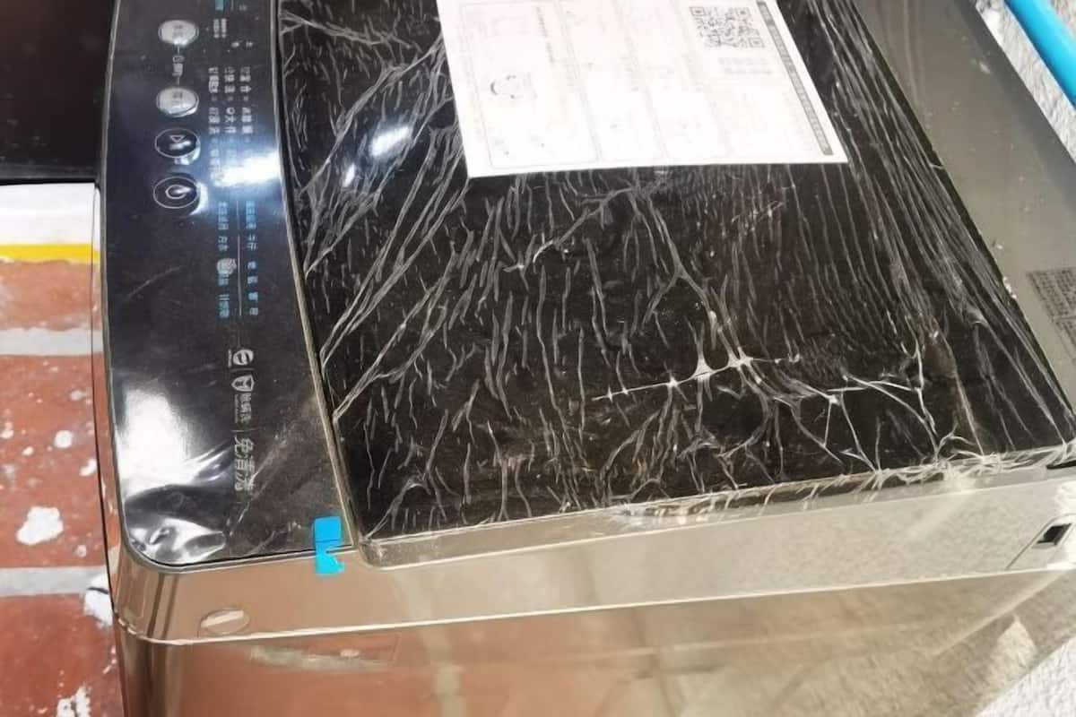 A laptop with a cracked screen, a visible sticker, and a barcode.