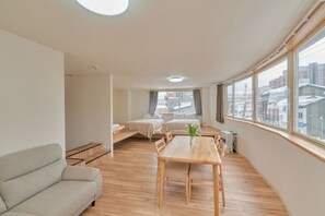 Moderni huoneisto, jossa on sohva, ruokapöytä ja sänky.