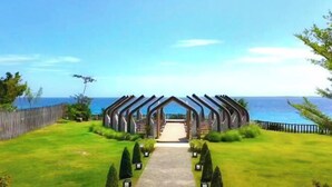 Un sendero lleva a una construcción de madera con vista al mar.